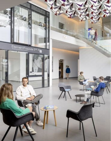 A couple of people sitting in the entrance hall of a company - Reynaers