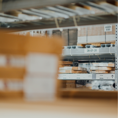 A warehouse or stockroom filled with brown and metal packages organized on shelves - Reynaers