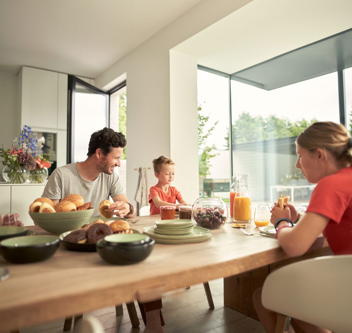 A family gathered around a table enjoying breakfast together - Reynaers